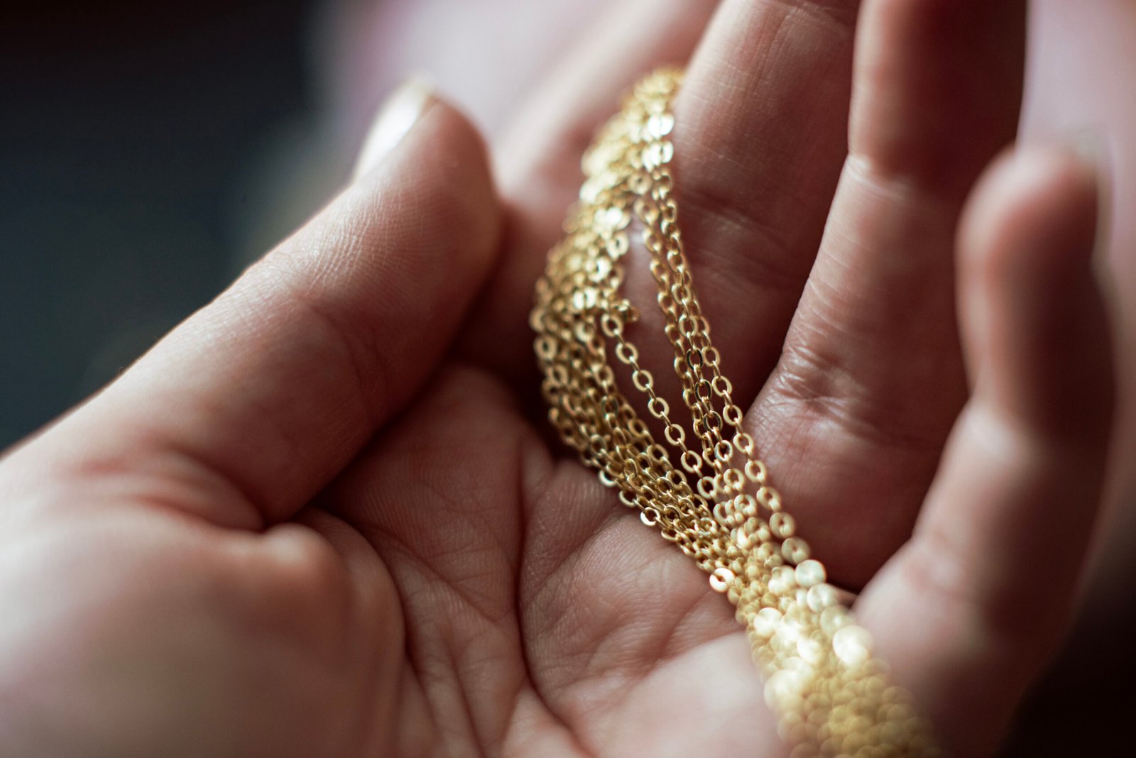 woman holding gold jewelry